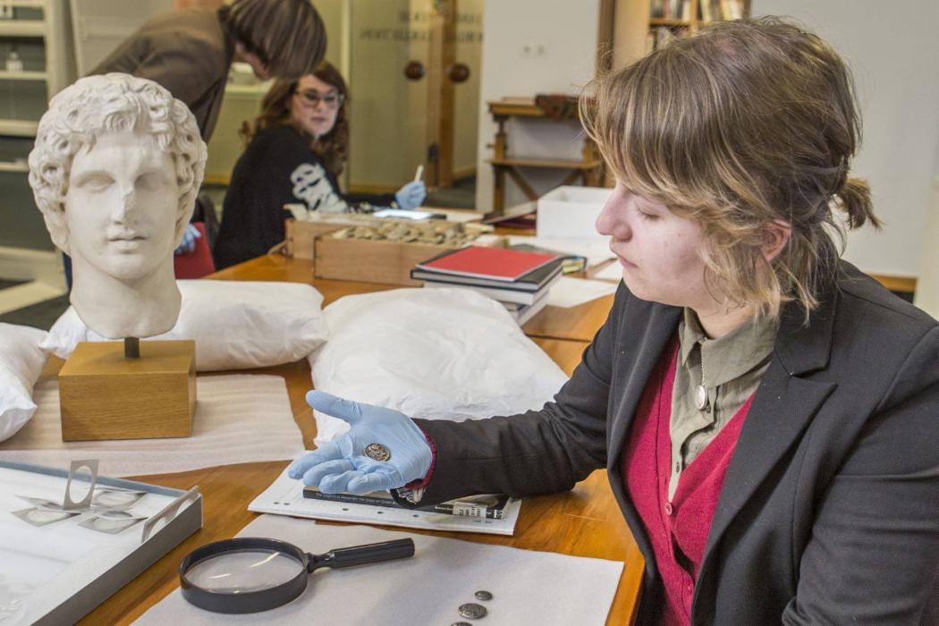 Student examines coin