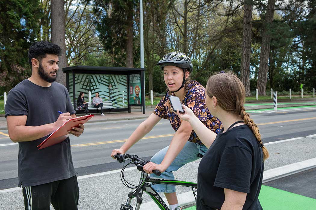 UC students doing a survey interview with a cyclist.