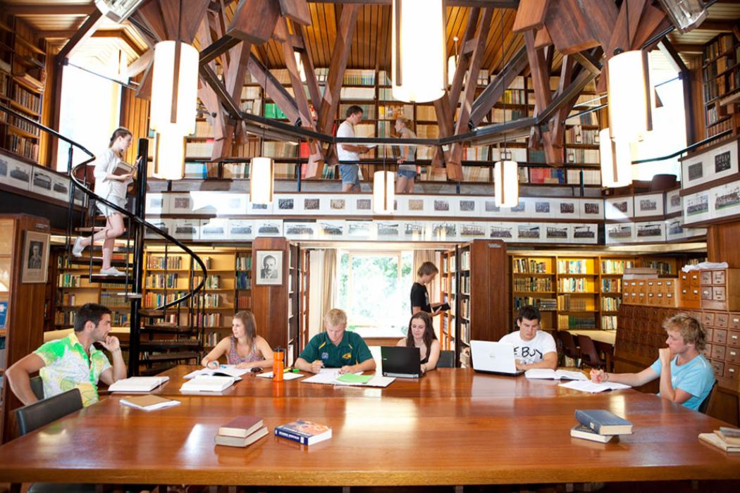 Students talking and studying in College house Library library 