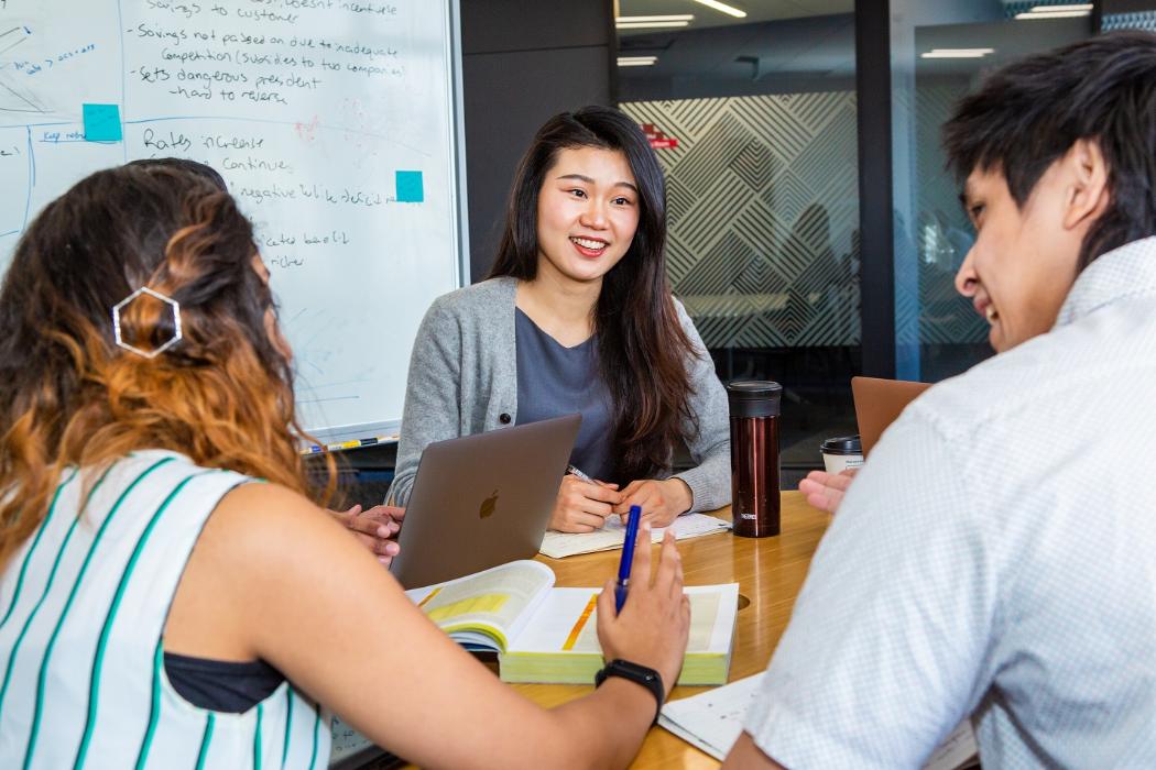 Three internship students in front of a whiteboard 